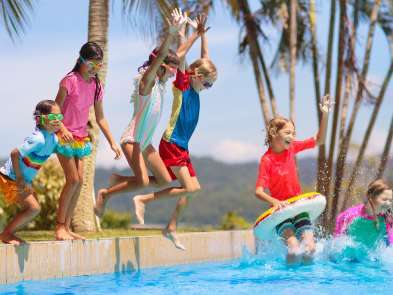 niños disfrutando en la piscina con bañadores llamativos